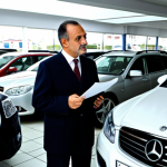 Home 5 Second-hand Car Dealership**
"A customer examining a second-hand car at a dealership in Istanbul. The salesperson, in professional attire, is explaining the car's features. Focus on the customer's thoughtful expression. Background: a busy car lot with various makes and models. Fully clothed, appropriate attire, safe for work, perfect anatomy, natural proportions, professional photography, high quality, family-friendly."
**